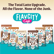 Five FlavCity Cafe Vanilla Latte drink mix packages are lined up beneath the text: The Total Latte Upgrade. Made with grass-fed whole milk and real coffee. The background features teal and cream colors.