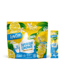FlavCity Superfood Lemonade powder package with lemon slices and green leaves on a white background