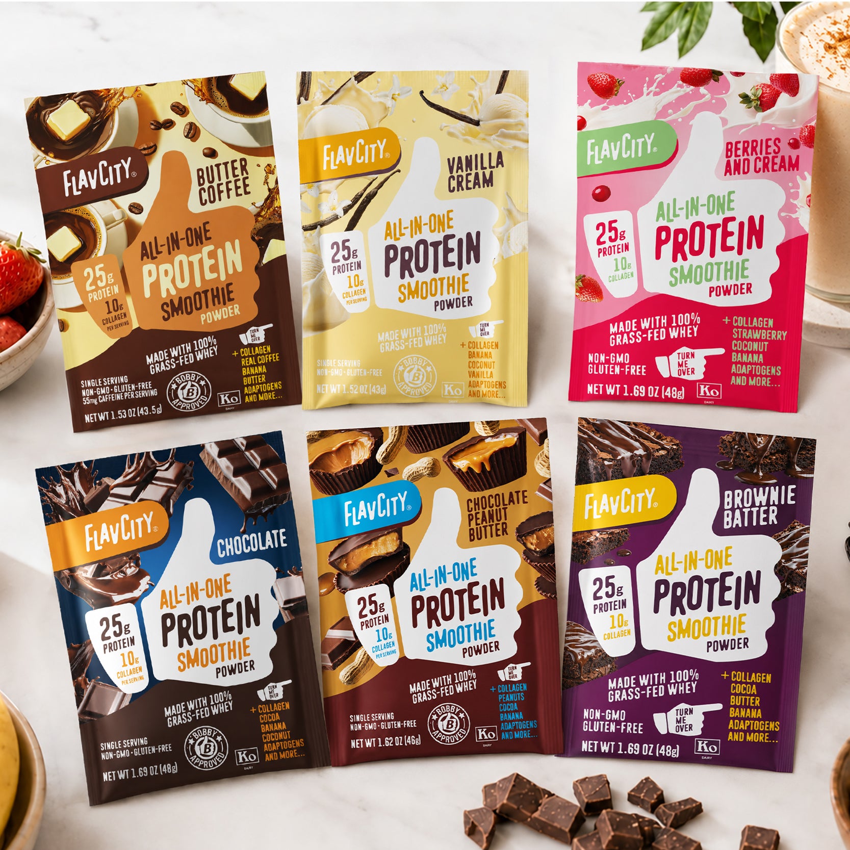 Six packets of Shop FlavCity All-In-One Protein Smoothie Packets—featuring grass-fed whey protein in flavors like Butter Coffee, Vanilla Cream, Berries & Cream, Chocolate, Peanut Butter Chocolate, and Brownie Batter—are displayed on a light surface.