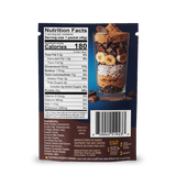 A FlavCity Cafe Bobby's Picks package shows a nutrition facts label and a barcode, with a glass full of chocolate, banana slices, oats, coconut flakes, peanuts, and grass-fed whey protein layered inside.