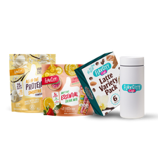 Four FlavCity Cafe products are shown: the Daily Ritual Bundle with Vanilla Cream Protein Smoothie, Lemon Anytime Essential Drink Mix, Latte Variety Pack, and a white FlavCity Cafe shaker bottle on a white background.