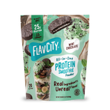 A pouch of Shop FlavCity Mint Chocolate Protein Smoothie powder, featuring images of a chocolate mint cookie, scoops of mint chip ice cream, a glass of the blended drink, and mint leaves to highlight this grass-fed whey and collagen blend.