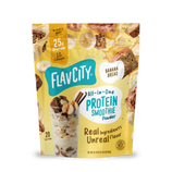 A yellow pouch of Shop FlavCity Banana Bread Protein Smoothie, featuring an illustration of the drink in a glass surrounded by banana slices and pieces of banana bread.