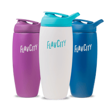 Three Shop FlavCity Shaker Bottles—purple, white with a turquoise lid, and blue—are displayed side by side on a white background, ideal for mixing lump-free shakes.