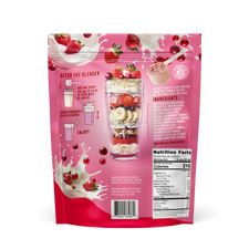 Back of FlavCity Berries and Cream protein smoothie powder package displaying nutrition information, layered smoothie glass, and floating strawberries with milk splashes on pink background.