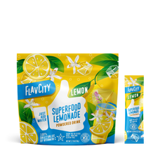 FlavCity Superfood Lemonade powder package with lemon slices and green leaves on a white background