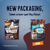 Side-by-side comparison of the original brown bag and new pouch of FlavCity Protein Smoothie Single-Serve Chocolate, featuring a glass of grass-fed whey smoothie and text announcing: New packaging, same crave-worthy flavor.