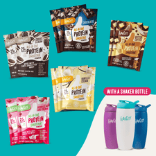 Five Shop FlavCity Protein Smoothies Starter Kit packets are displayed with three branded shaker bottles (purple, blue, and white) on a teal background. Text reads: WITH A SHAKER BOTTLE.
