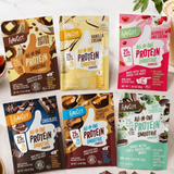 Six Build Your Own Protein Smoothie Packets from Shop FlavCity—featuring flavors like Butter Coffee, Vanilla Cream, Berries and Cream, Chocolate, Peanut Butter Chocolate, and Mint Chocolate—each enriched with collagen and functional mushrooms—are arranged on a white surface.