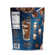 The back of the Shop FlavCity Chocolate Protein Smoothie bag displays a nutrition label, mixing directions, and images of a chocolate protein smoothie with mix-ins. Set against a blue background with orange text and graphics, it features premium grass-fed whey and highlights the phrase “Shake your expectations” near the bottom.