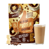 A bag of Shop FlavCity Butter Coffee Protein Smoothie stands behind a glass filled with a rich brown smoothie. Coffee beans and cubes of butter are artfully arranged in front, highlighting this delicious protein smoothie blend.