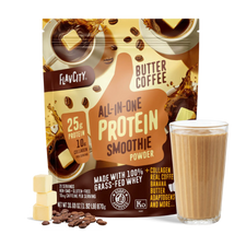 A bag of Shop FlavCity Butter Coffee Protein Smoothie stands behind a glass filled with a rich brown smoothie. Coffee beans and cubes of butter are artfully arranged in front, highlighting this delicious protein smoothie blend.