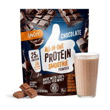 A bag of Shop FlavCity Chocolate Protein Smoothie is displayed alongside a glass of prepared chocolate protein smoothie and pieces of chocolate. The packaging highlights 25g protein, 10g collagen, and ingredients such as cocoa, banana, and grass-fed whey.