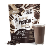 A bag of Shop FlavCity Cookies & Cream Protein Smoothie stands behind a glass of chocolate smoothie and some cookies scattered on a white surface.