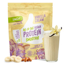 A container of Shop FlavCity Plant-Based Vanilla Protein Smoothie stands behind a glass of dairy-free smoothie garnished with a vanilla flower and pod, surrounded by sliced banana and whole almonds.