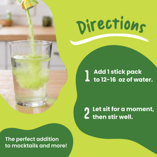 A hand pours a stick pack of Lemon Lime Electrolyte Mix into a glass of water, following instructions to mix with 12-16 ounces for real fruit electrolytes in a mocktail.