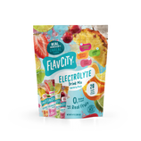 A stand-up pouch of Shop FlavCity Variety Pack Electrolyte Mix surrounded by fresh fruit, featuring 28 single-serve sticks in four flavors: strawberry limeade, pineapple coconut, lemon lime, and fruit punch.