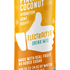 FlavCity Pineapple Coconut Electrolyte Drink Mix stick pack with a yellow and orange design. The packaging features a white thumb-up graphic and text promoting 'Hydration done right,' 'Made with real fruit,' 'No added sugar,' and 'Bobby Approved,' with illustrations of coconut halves, pineapple slices, and tropical leaves.